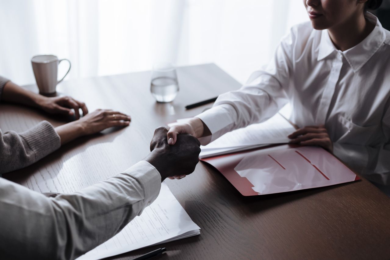 Two people sealing a handover across a table